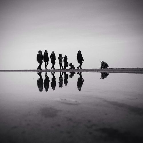Group of people with reflection on beach
