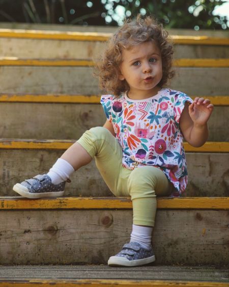 Cute girl looking away while sitting outdoors