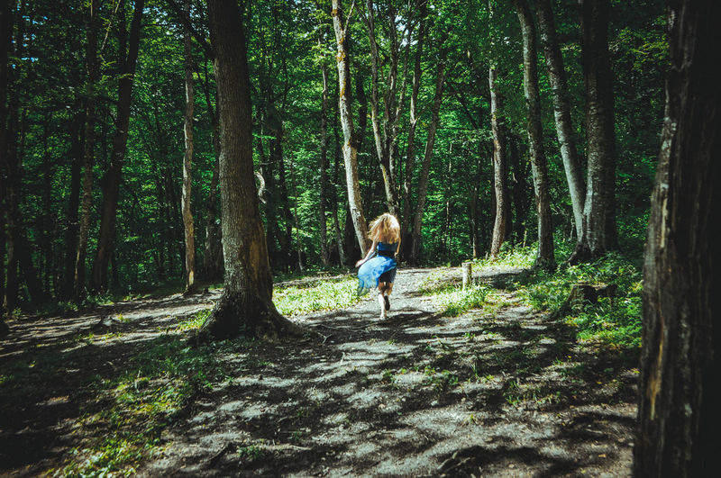 Rear view of woman running in forest