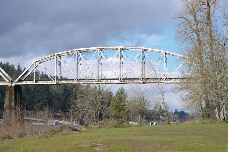 Arch bridge on field against sky