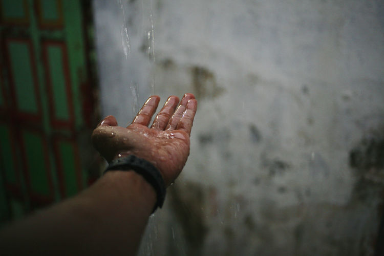 Cropped image of person hand on rainy season