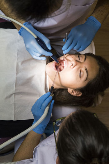 Overhead view of dentists giving treatment to patient at medical clinic