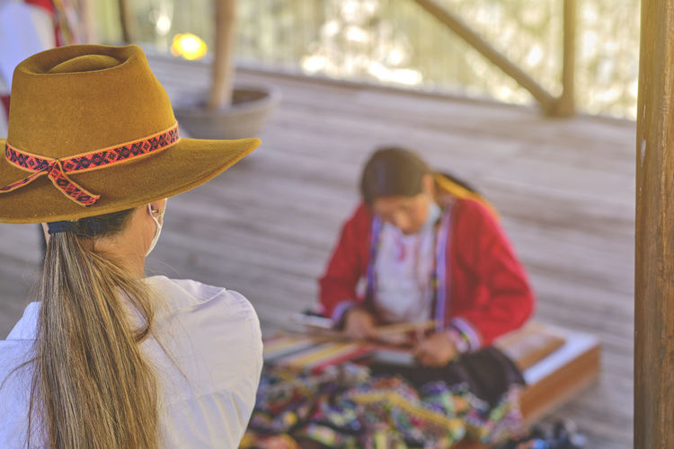 Indigenous woman showing traditional weaving technique and textile making in the andes mountain 