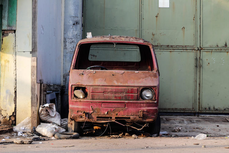 Old rusty car against wall
