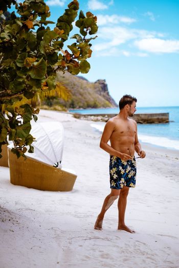 Shirtless man standing on beach