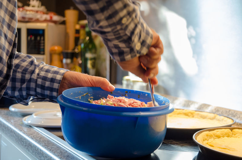 Midsection of person preparing food on kitchen counter at home