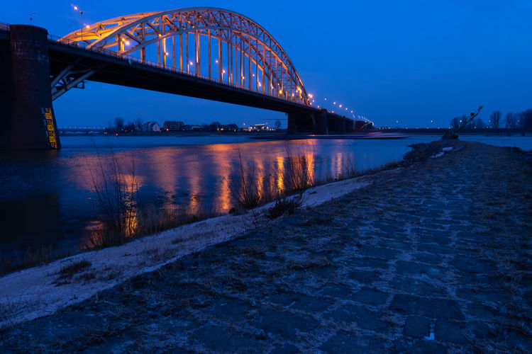 View of bridge over river at dusk
