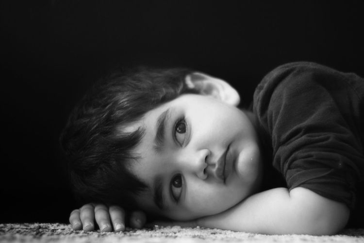 Close-up portrait of cute boy lying down