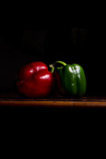 Close-up of red bell peppers on table against black background