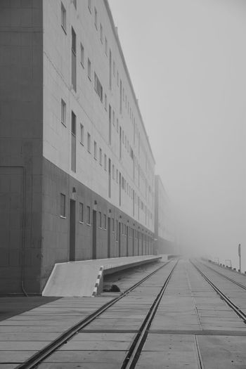 Railroad tracks amidst buildings in city against sky
