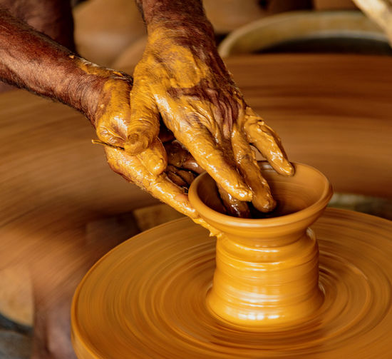 Midsection of person working on potters wheel