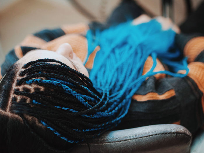 High angle view of woman with dyed dreadlocks sitting on chair