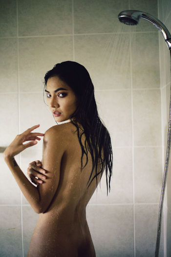 Portrait of seductive woman taking shower in bathroom