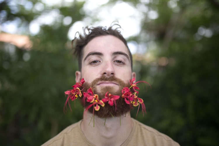 Man with tropical flowers in beard