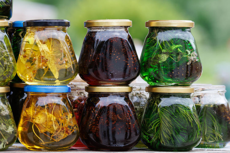 Glass jars with favoured honey - with linden, herbs and pine needles, close-up