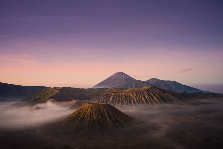 Scenic view of volcanic landscape against sky during sunset