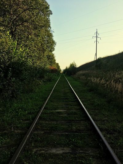 Railroad track amidst field against sky