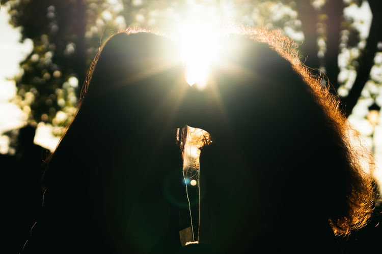 Close-up portrait of woman holding plant on sunny day