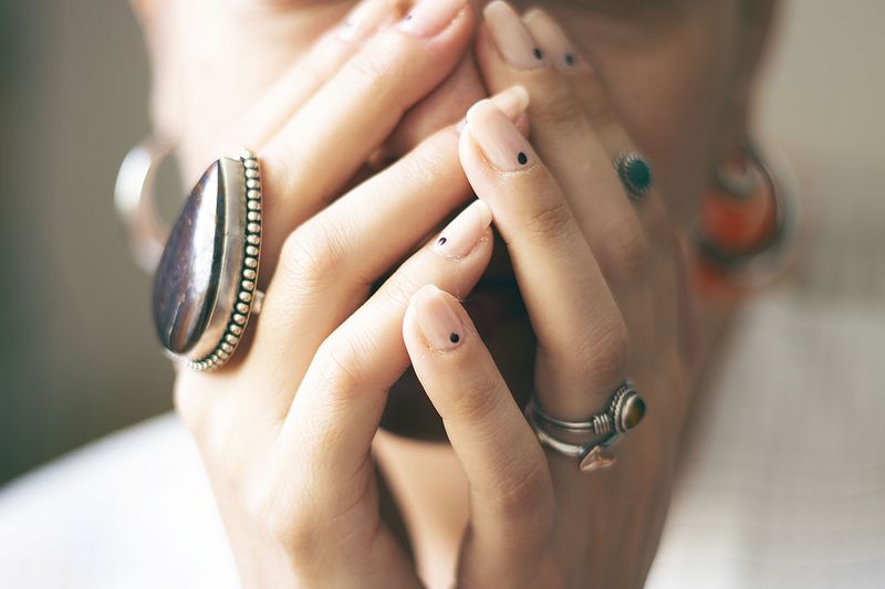 Close-up of woman with hands covering mouth