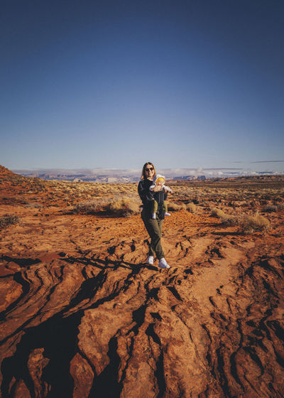 A woman with a child is standing near horseshoe bend, arizona