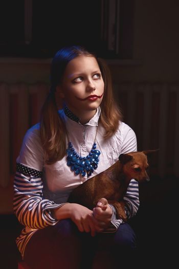 Young woman with dog sitting at home