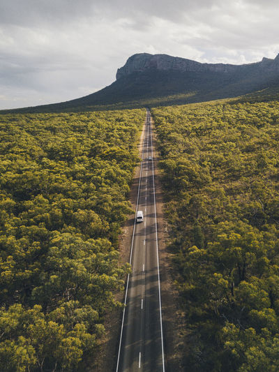 Aerial campervan driving through the endless road towards mountains at the grampian national park, victoria, australia