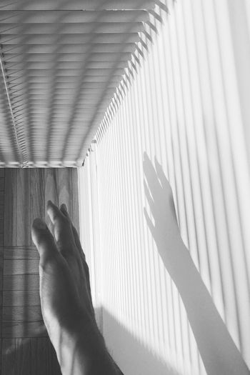 Cropped image of hand with shadow on wall