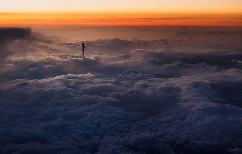 Silhouette of woman above the clouds