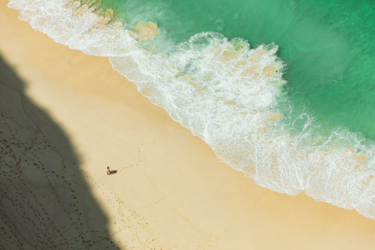 Aerial view of woman sitting on beach