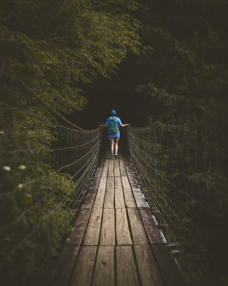 Rear view of woman walking on footbridge