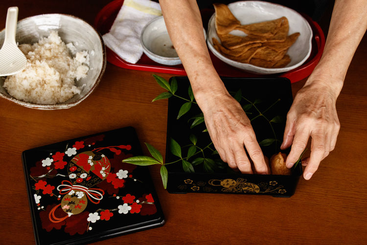 Cropped hand of woman preparing food on table.