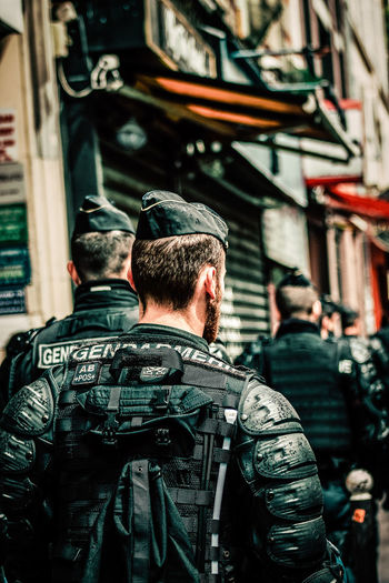 Rear view of police force on street in city