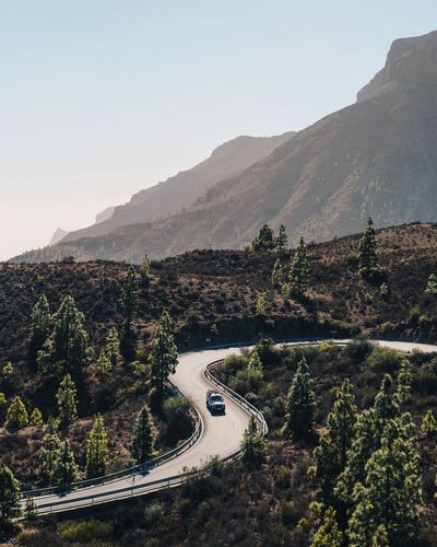 High angle view of road by mountains against clear sky