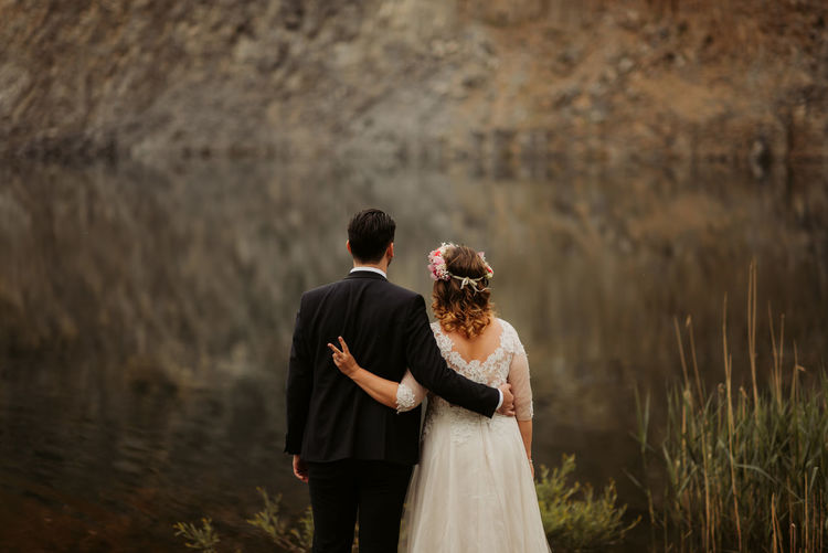 Wedding couple standing by lake