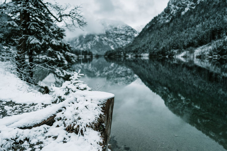 Scenic view of lake by snowcapped mountains during winter