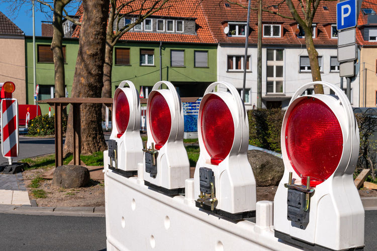 Construction plastic white barrier at a road with red reflecting lamps as safety installation.