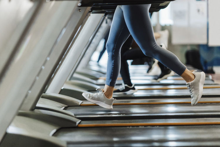 Male and female athlete exercising on treadmill in gym