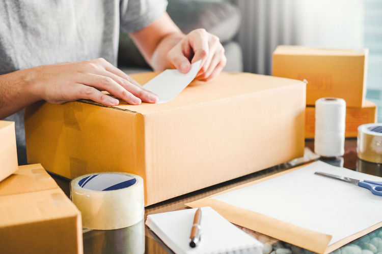 Midsection of man packing box
