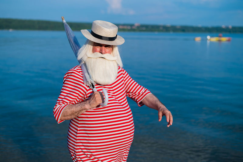 Midsection of woman wearing hat standing in water