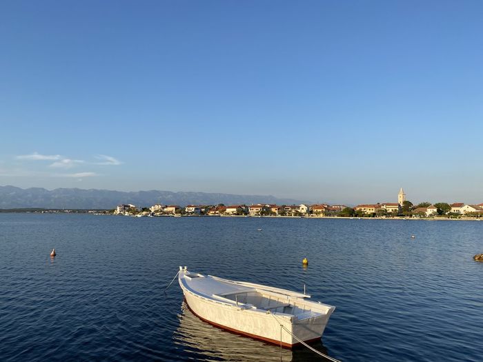 Sailboats in sea against blue sky