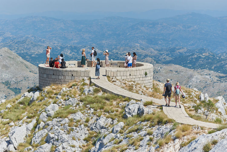 People walking on mountain in viewpoint of lovcen national park 