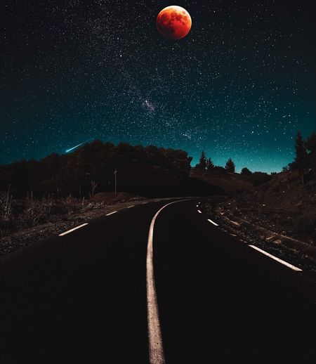 Road against sky at night