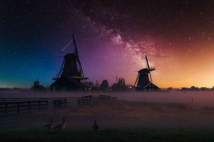 Traditional windmill against sky at night