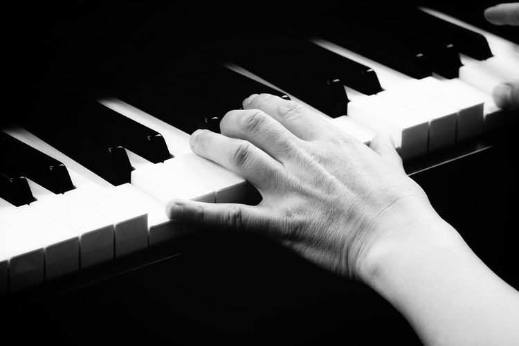 Close-up of hand playing the piano