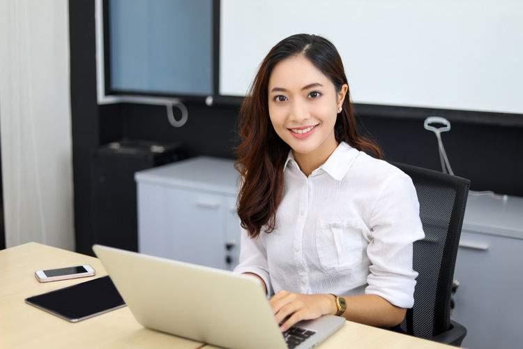 Portrait of young businesswoman using laptop at home