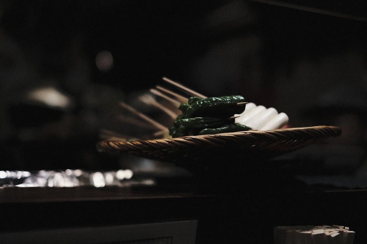 Close-up of food on wicker basket in darkroom