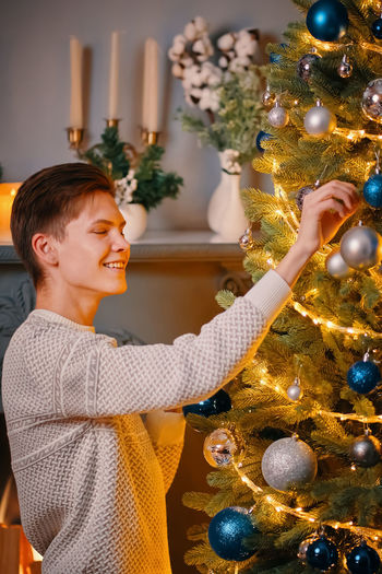 Full length of smiling boy in christmas tree
