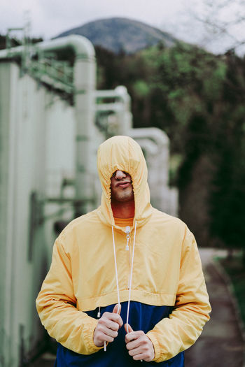 Man wearing hooded shirt while standing outdoors