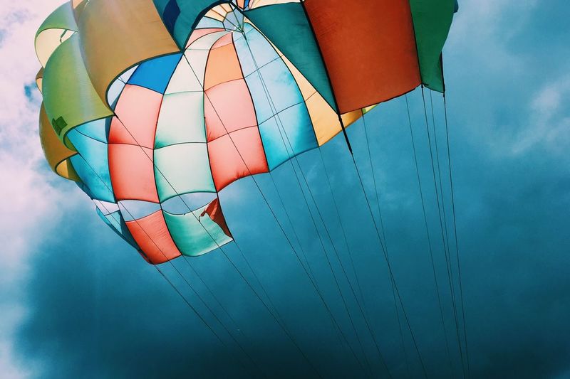 Low angle view of colorful parachute against sky