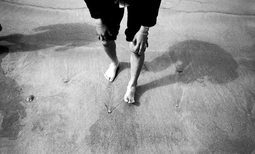 Person at beach resting hand on knee